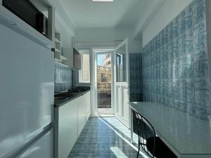 eine Küche mit weißen Schränken und blauen Wandfliesen in der Unterkunft Airy & Beautiful Downtown Apartment in Bukarest