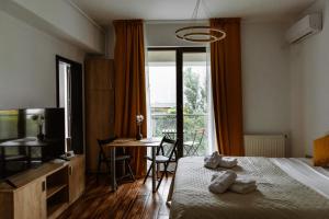 a hotel room with a bed and a table and a window at Zen Studio 1 with balcony in Bucharest