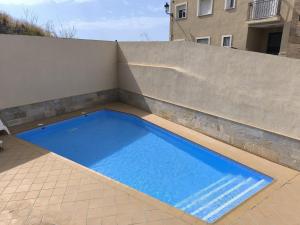 a large blue swimming pool sitting on top of a wall at Casa Cati in La Herradura