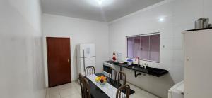 a kitchen with a counter and a sink and a refrigerator at Casa Nova temporada piscina aquecida 24hs in Olímpia