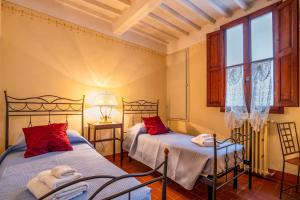een slaapkamer met twee bedden en een raam bij Sweet Tuscany I Due Gigli in Arezzo