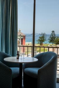 a table and chairs with a view of the ocean at Alloggio Newcastle Beach in Newcastle