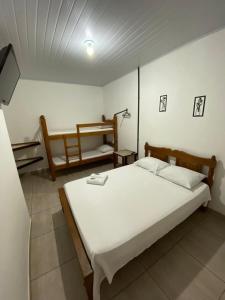 a bedroom with a large white bed in a room at Hospedagem De Ferias in Bonito