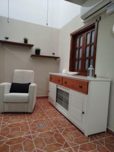 Una cocina con un sofá y una silla en una habitación. en La casa de Rei, en Sardina