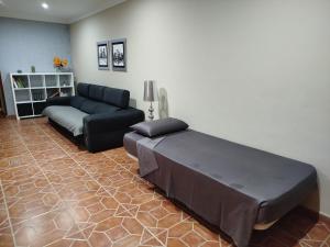 una sala de estar con una cama y un sofá en La casa de Rei, en Sardina