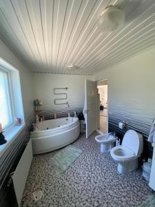 a bathroom with two toilets and a tub and a sink at Nordic Villa in Husum