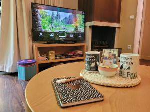a living room with a coffee table with a tv at Hakuna Matata domaine des 3 forets-PMR-6 personnes sauna balneo-acces aquamondo non inclus in Hattigny