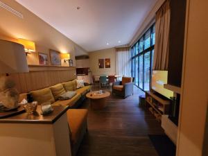 a living room with a couch and a table at Hakuna Matata domaine des 3 forets-PMR-6 personnes sauna balneo-acces aquamondo non inclus in Hattigny