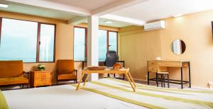 a living room with a table and chairs and windows at Grand Appart'Antaninarenina in Antananarivo +291 photos