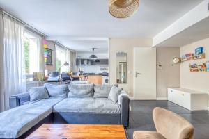 a living room with a blue couch and a kitchen at Bel appartement Bordeaux centre in Bordeaux