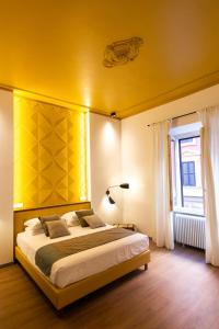 a bedroom with a large bed with a yellow wall at Trevi Monti House in Rome