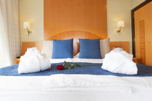 a bed with two pillows with flowers on it at R2 Hotel Pajara Beach in Costa Calma