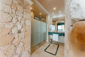 a bathroom with a stone wall at R2 Rio Calma in Costa Calma