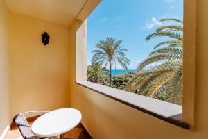 a window with a view of the ocean and palm trees at R2 Rio Calma in Costa Calma