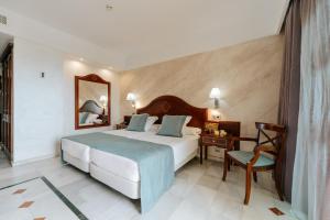 a bedroom with a bed and a desk and a chair at R2 Rio Calma in Costa Calma