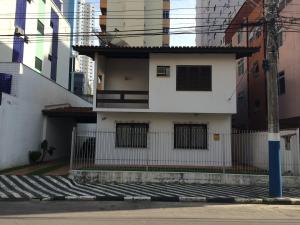 a white house with a fence in a city at Casa Germano 251 in Balneário Camboriú