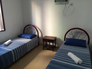 - deux lits assis l'un à côté de l'autre dans une pièce dans l'établissement Casa Germano 251, à Balneário Camboriú
