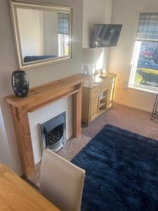 a living room with a fireplace and a mirror at Cozy 2 BDRM Apartment Nr the World Heritage Site of Saltaire in Saltaire