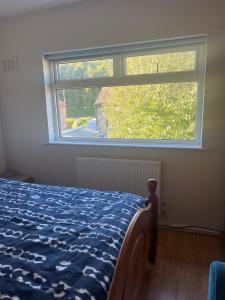 a bedroom with a bed and a large window at Cozy 2 BDRM Apartment Nr the World Heritage Site of Saltaire in Saltaire