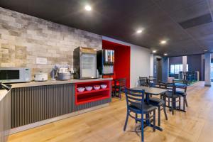 a kitchen with a table and some chairs and a counter at Spot X Hotel Wesley Chapel - Tampa Area in Wesley Chapel