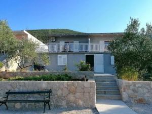 a house with a bench in front of it at Holiday Home Blue Dream - Two Bedroom Apartment with Terrace and Sea View A1 in Putniković +18 photos