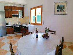 a kitchen with a table with a bottle of wine and a bowl of fruit at Holiday Home Blue Dream - Two Bedroom Apartment with Terrace and Sea View A1 in Putniković