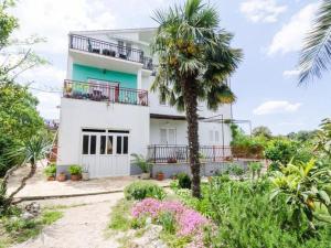 una casa bianca con una palma di fronte di Apartment Sutvid with one bedroom a Drače