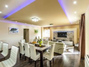 a dining room and living room with a table and chairs at Villa Pave - Six-Bedroom Villa with Terrace and Swimming Pool in Dubravka