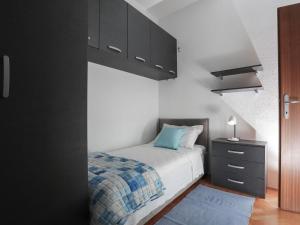 a bedroom with a bed and black cabinets and a blue rug at Apartment Tonka - Two Bedroom Apartment - ST in Supetar