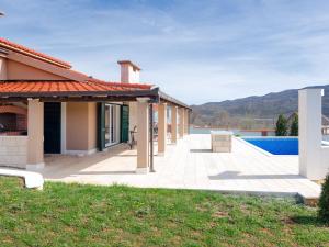 a house with a patio and a swimming pool at Villa Dea - Luxury Villa with Outdoor Swimming Pool in Vučevica