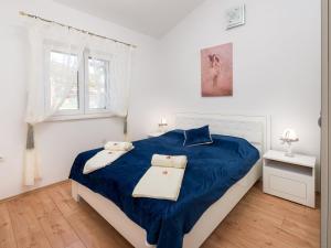 a bedroom with a bed with blue sheets and a window at Villa Dea - Luxury Villa with Outdoor Swimming Pool in Vučevica +26 photos