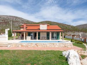 a house with a swimming pool in front of a house at Villa Dea - Luxury Villa with Outdoor Swimming Pool in Vučevica