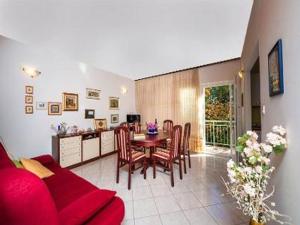 a living room with a red couch and a table at Holiday Home Lido - Three Bedroom Holiday House with Terrace in Orebić