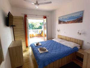 a bedroom with a bed with a blue comforter at Apartments Vinko Mljet- One-Bedroom Apartment with Terrace A4 in Sobra