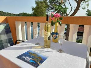 a table with a bottle of wine and two glasses at Apartments Vinko Mljet- One-Bedroom Apartment with Terrace A4 in Sobra