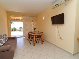 Una sala de estar con una mesa y un televisor en la pared. en Apartments Villa Michele-One Bedroom Apartment with Terrace Smokva, en Orebić