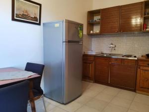 a kitchen with a stainless steel refrigerator and a table at Apartment Tina - One Bedroom Apartment with Terrace in Smokvica