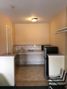eine Küche mit einem schwarzen Kühlschrank und einer Spüle in der Unterkunft Residents Suites Liberty in Liberty