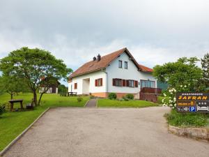 a white house with a driveway in front of it at Guesthouse afran- Two Bedroom Apartment in Plitvička Jezera