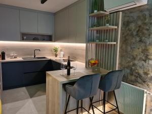 a kitchen with two bar stools and a sink at Wellness Apartments - Studio Apartment with Terrace G3 in Varaždin