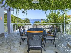 - une table et des chaises sur une terrasse avec vue sur l'eau dans l'établissement Apartments Vesela - One Bedroom Apartment with Balcony and Sea View, à Janjina