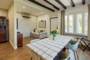 a dining room with a table and chairs and a couch at Villa Allegra Apartments in The Nature in Pozzolgroppo