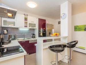 カルロバッグにあるApartments Paola - Two Bedroom Apartment with Terrace and Sea viewの赤いキャビネットと黒い椅子が備わるキッチン