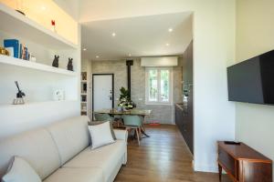 a living room with a white couch and a table at Villa Allegra Apartments in The Nature in Pozzolgroppo