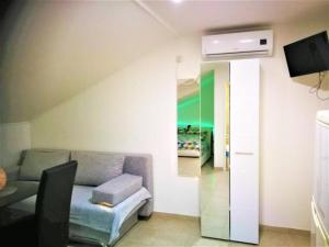 a living room with a couch and a tv in a room at Apartments Milic - Studio Apartment with Sea View 4 - 2 in Gornji Karin