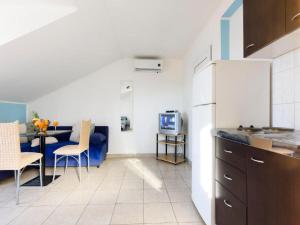 a kitchen and living room with a table and a couch at Apartments Milic - Studio Apartment with Sea View 4 - 2 in Gornji Karin