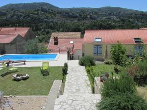 a garden with a swimming pool and a house at Holiday Home Stari Zoganj - Two Bedroom Holiday Home with Terrace and Swimming Pool in Potomje