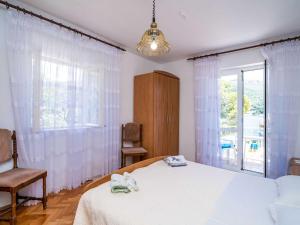 a bedroom with a bed and a large window at Apartments Zarac - One Bedroom Apartment with Balcony and Sea View Milanka in Zaton