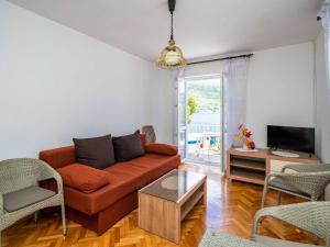 a living room with a couch and a tv at Apartments Zarac - One Bedroom Apartment with Balcony and Sea View Milanka in Zaton