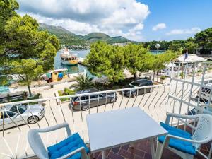 a balcony with a table and chairs and a boat in the water at Apartments Zarac - One Bedroom Apartment with Balcony and Sea View Milanka in Zaton